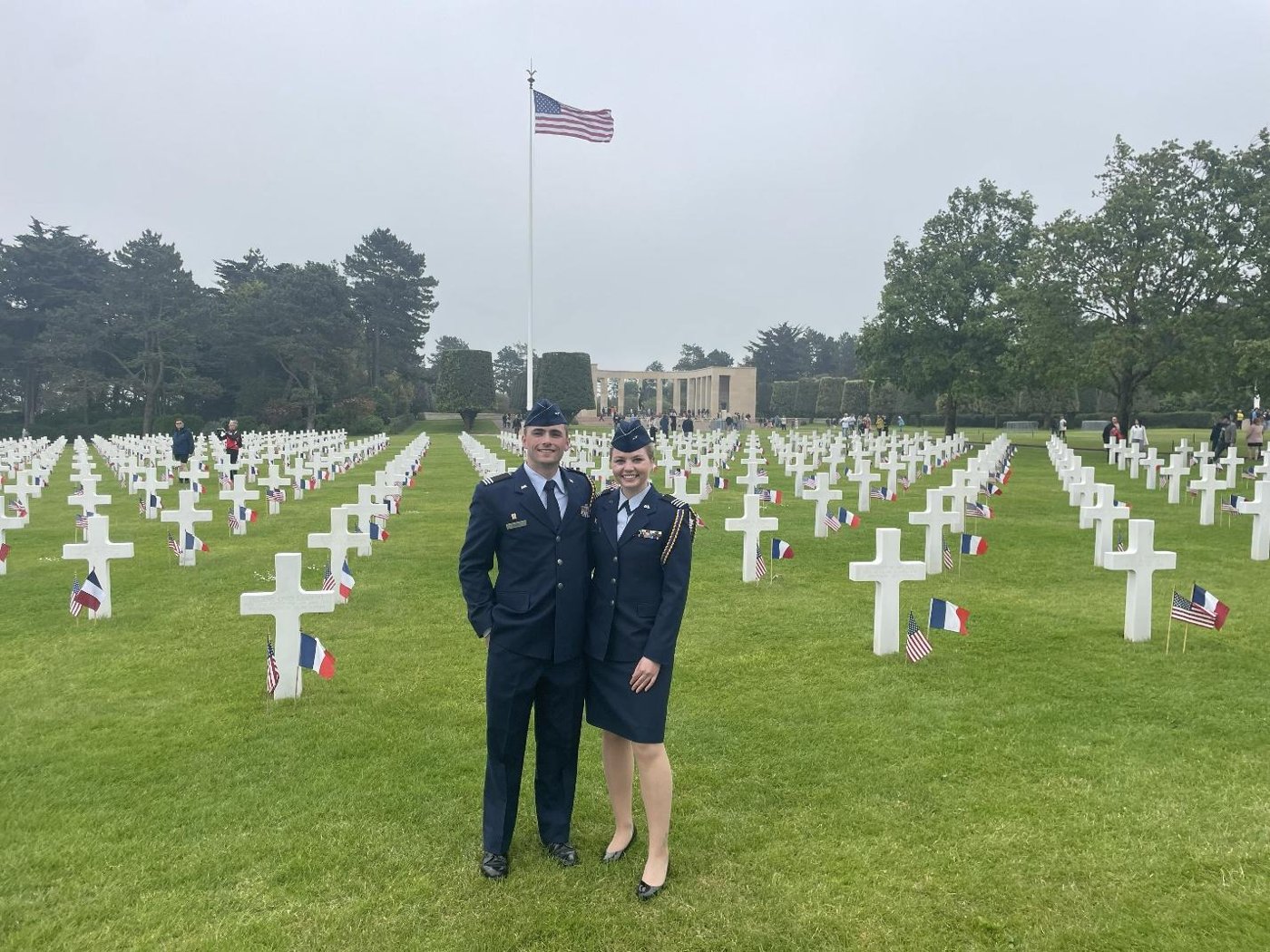 Two Air Force ROTC cadets in dress uniform standing among rows of white headstones