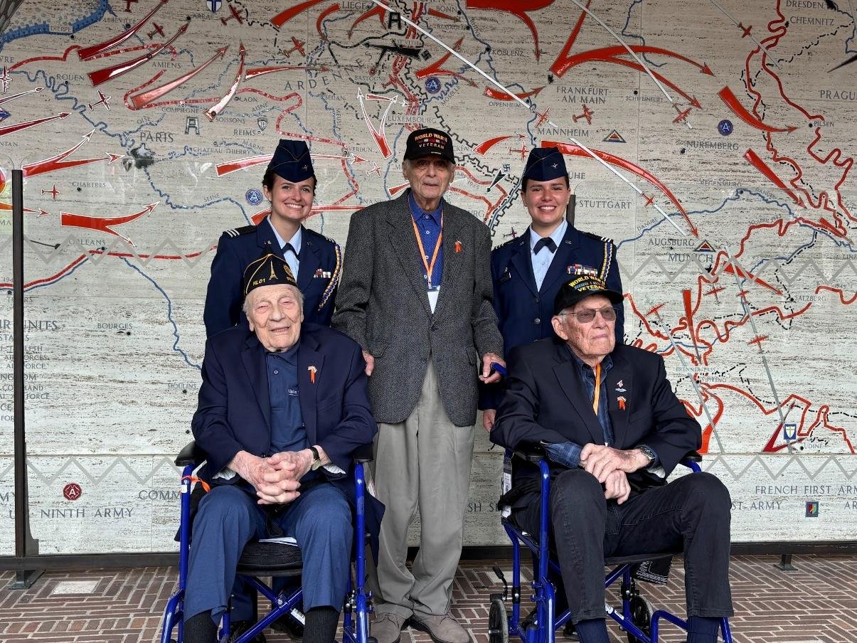 Two Air Force ROTC cadets with three WWII veterans in front of a battle map