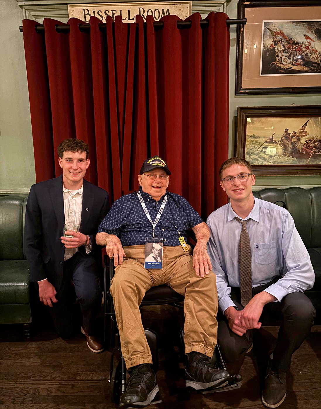 WWII Navy veteran Arthur Grabiner seated between two 2026 Fellows at Fraunces Tavern