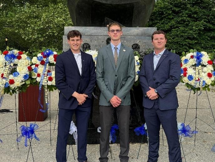 The three 2026 ABMF Fellows standing among memorial wreaths at the East Coast Memorial in New York City